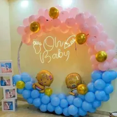 A cute 'Oh Baby' decoration with a half-arch of pink and blue balloons. The transparent 'BABY' boxes and baby-shaped foil balloons complete the theme.