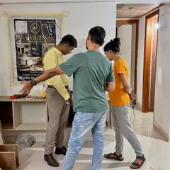 A site visit with clients, where we are mapping out the furniture layout and electrical points directly on the wall. This helps everyone visualize the space.