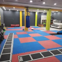This is our dedicated matted zone. It's a versatile space for martial arts fitness, agility drills using the ladder, and floor exercises. The punching bag is always ready for a high-intensity cardio and striking session.