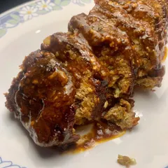 A generous slice of our juicy Pork Meatloaf, covered in a rich, savory glaze. We make it with quality pork mince, the right amount of fat, and fresh herbs from our garden in Coorg.