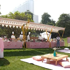The catering station for the outdoor picnic event. We designed a long tented stall with pink and white patterned skirting to match the romantic, playful theme of the day.