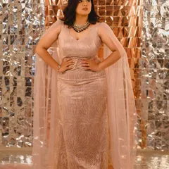 Meghana looking powerful and poised. This full-length shot shows off her stunning gown, and the makeup was created to complement its modern, elegant design.
