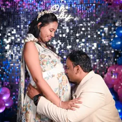 A classic and heartwarming moment from a baby shower where the dad-to-be kisses the baby bump. It’s a beautiful expression of his love and excitement, captured against the fun, celebratory backdrop of their party.