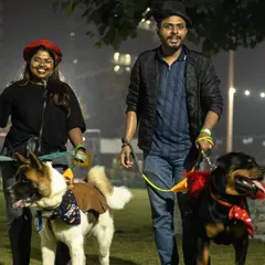 A couple enjoys a walk with their Akita and Rottweiler, all dressed up for the Halloween party. My events are a great way for the whole family to participate.