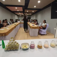 A view from the front of a Face Yoga workshop, showing the setup with natural ingredients and jars for participants to create their own face packs.