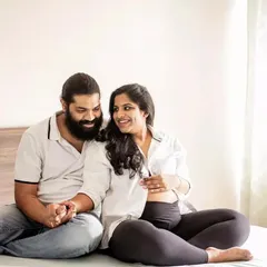 Holding hands and sharing smiles. This is what a cozy, at-home pregnancy photoshoot is all about, capturing the simple, happy moments together before the baby comes.
