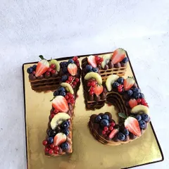 Our cream tart cakes are a great alternative to a traditional cake. This one, in the shape of the number 75, is layered with chocolate cream and topped with fresh berries.