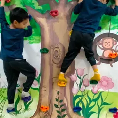 Two boys carefully navigate their way up the colorful holds on our indoor climbing wall. It's a safe and fun way to introduce kids to rock climbing.