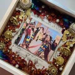 This piece captures the grandeur of a traditional wedding. I preserved the couple's varmala, complete with intricate golden kaleera pieces and pearls, around their photo in a beautiful white wooden frame.
