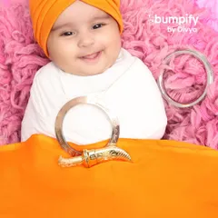 A beautiful smile from our little Sardar. For this Sikh-themed newborn shoot, I used a soft orange turban and traditional symbols like the kara and kirpan to create a meaningful and adorable portrait.