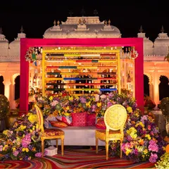 Vibrancy and tradition come together in this Mehendi seating I designed against the regal backdrop of Shiv Niwas Palace. I love playing with rich colors, lush florals, and unique backdrops like this one made of colorful bangles to create a joyful and photogenic atmosphere for your pre-wedding events.