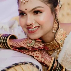 A radiant smile from a beautiful bride. This close-up portrait captures her happiness and the stunning details of her makeup, nath (nose ring), and wedding jewelry.