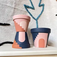 Inspired by architectural shapes and desert colors, these hand-painted planters feature abstract arch and stair designs. They bring a warm, contemporary feel to your plant display.