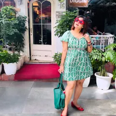 A full-length shot of my green and red 'Calm + Fire' outfit outside Diggin cafe. This image highlights the color-blocking and accessories, including the heart-shaped sunglasses and matching bag.