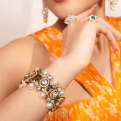 In this photo, a stunning polki and pearl bracelet, which doubles as a choker, is paired with matching pearl chandbalis and diamond rings. It’s a complete look that showcases the beauty of versatile design.