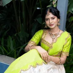A sitting portrait of the model, giving a clearer view of the intricate choker and maang tikka from our silver collection.