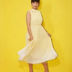 A full-length shot of a model in a flowing yellow dress, part of our "Summer Edit." We offer flat discounts to help you achieve your ultimate summer glow-up.