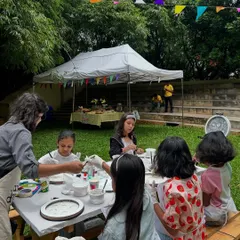 I guide the kids step-by-step, so no one ever feels lost. Here, I'm helping a group get started on their moon lamp project at a fun outdoor birthday celebration.