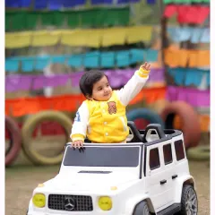 Cruising in style! This outdoor shoot with a miniature G-Wagon and a colorful backdrop is perfect for capturing the cool and playful side of your little one.