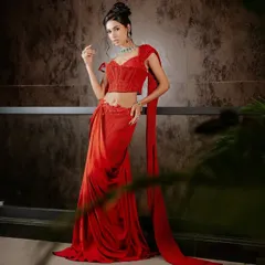 A full-length view of the ruby red corset sari. The fluid drape of the skirt and pallu contrasts beautifully with the structured, tailored corset, creating a powerful modern Indian silhouette.