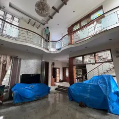 I handle projects of all sizes, including large duplex homes with high ceilings and complex layouts. This photo shows my team carefully prepping a spacious living area, ensuring all furniture is securely covered before we begin the interior painting process.
