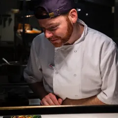 Capturing a chef in their element. This candid action shot from a London restaurant kitchen tells a story of focus, craftsmanship, and dedication to the final dish.