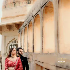 A quiet moment against the warm, textured walls of a Rajasthani fort. The contrast between his dark suit and her vibrant lehenga stands out beautifully. This is a great example of a serene, editorial-style portrait from a destination couple shoot.