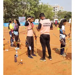 A great coach makes all the difference. During a competition, I take the time to give last-minute advice and encouragement to one of our young archers, ensuring she feels supported and ready.