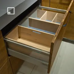 We customize drawer interiors to fit your needs. This image shows a deep drawer fitted with wooden organizers, perfect for keeping cutlery, socks, or other small items neatly separated and easy to find.