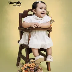 Pure happiness. This little girl's joyful laugh is captured perfectly in this classic studio portrait, using a vintage high chair and a simple, warm background.