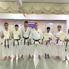 The gang from our Silicon City dojo poses with their new certificates after a successful belt exam, standing alongside their proud senseis.