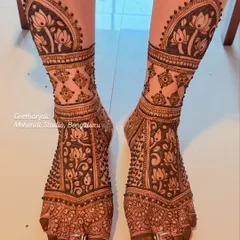 A full coverage foot mehendi for a baby shower, with beautiful lotus and geometric patterns extending up the shin.