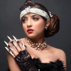 A full view of the retro-inspired fantasy nails, showcasing their dramatic length and the combination of hand-painted art, feathers, and embellishments.