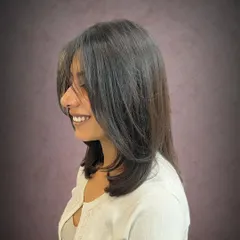 A side view of the long bob with face-framing curtain bangs.