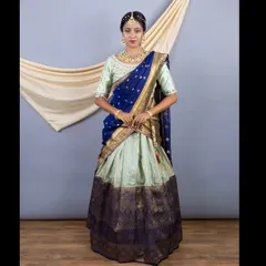 A full-length view of the beautiful Pattu silk half saree. The rich royal blue and gold border contrasts beautifully with the lighter mint green of the skirt.
