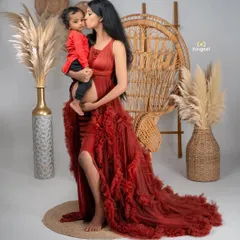 A mother's love, already in full bloom. This stunning maternity portrait in a flowing red gown also includes her older child, beautifully capturing the family's growing love.