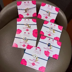 Protect your sibling with this elegant personalised evil eye rakhi. Blending tradition with modernity, these rakhis come with an initial charm for a personal touch.