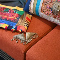 A detail shot of the old silver jewelry pieces used to embellish the Banjara textiles. These found objects add an authentic, historical touch to the final creation.