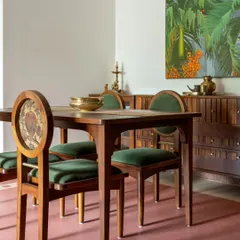 The dining set at Layam, featuring chairs with a medley of wood, brass, and a dual-fabric approach for practicality and visual appeal. The chest of drawers behind it has details that resemble the "beats" of music.