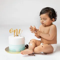 Examining the frosting-covered hands. The curiosity and delight of a cake smash are what make these sessions so special and fun.