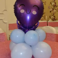 A simple and adorable balloon table centerpiece. This piece features a purple octopus foil balloon on a base of light blue balloons, perfect for an underwater or mermaid-themed party.