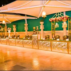 An elaborate and elegant buffet setup for a wedding reception. I believe that even the food service area should be beautifully decorated to match the event's aesthetic, using custom counters and floral arrangements.