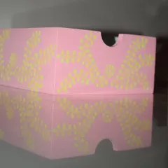 A side view of my hand-painted organizer, showing the delicate floral pattern against the pastel pink. The reflection highlights the smooth finish of this functional art piece.