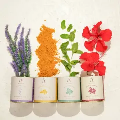A creative flat-lay of four different herbal tea blends, with their respective ingredients like lavender, turmeric, and hibiscus flowers arranged beautifully. This shot showcases the variety and natural origins of the products.