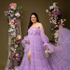 A full-length portrait in a dreamy lavender gown. The thigh-high slit and flowing fabric add a touch of glamour, while the floral arches create a romantic, garden-like feel.