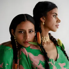 An intimate dual portrait for Esha Arora. The composition is soft and romantic, focusing on the models' connection and the details of their hair, jewelry, and printed garments.