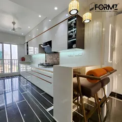 A closer look at the breakfast bar in this open-plan kitchen. The clean white countertop and warm lighting make it an inviting spot for a quick meal or a morning cup of coffee.