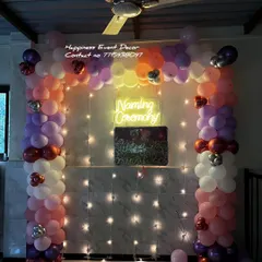 Here is the same naming ceremony balloon arch, but with fairy lights added to the backdrop. This small addition creates a sparkling and festive effect, perfect for evening celebrations.