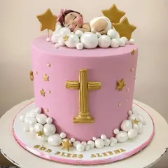 A dreamy christening cake in pink and gold. The design features a sleeping baby nestled in fluffy, pearlized clouds under golden stars, with a prominent cross on the front. It’s a sweet and serene cake for a blessed occasion.
