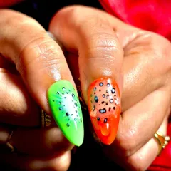 A detailed shot of kiwi and papaya-inspired nail art, showcasing creative use of color and texture.